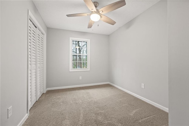 unfurnished bedroom with a closet, baseboards, carpet, and a ceiling fan