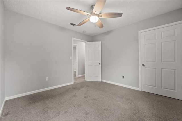 unfurnished bedroom with visible vents, a ceiling fan, a textured ceiling, carpet floors, and baseboards