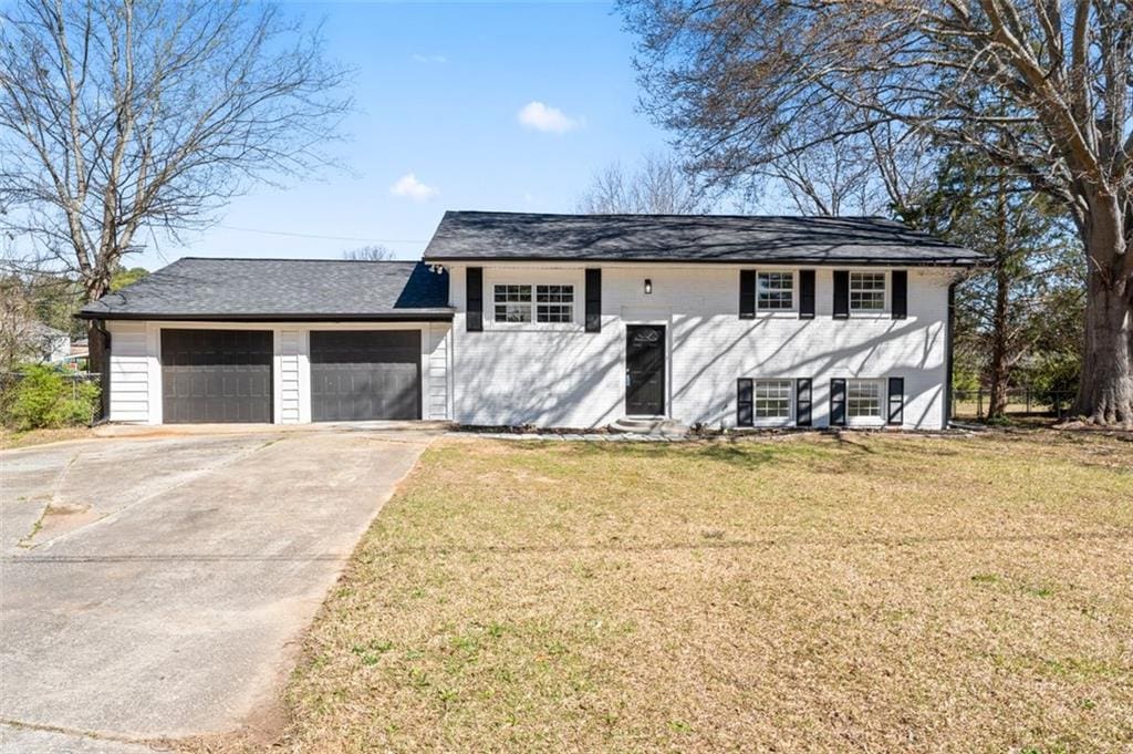 view of front of house featuring driveway, a garage, and a front lawn