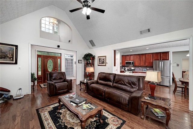 living room with dark hardwood / wood-style flooring, a textured ceiling, high vaulted ceiling, and ceiling fan with notable chandelier