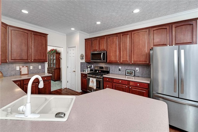 kitchen with dark hardwood / wood-style floors, a textured ceiling, appliances with stainless steel finishes, and sink