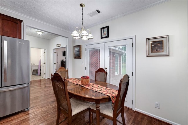 dining room featuring a chandelier, french doors, a textured ceiling, and dark hardwood / wood-style flooring