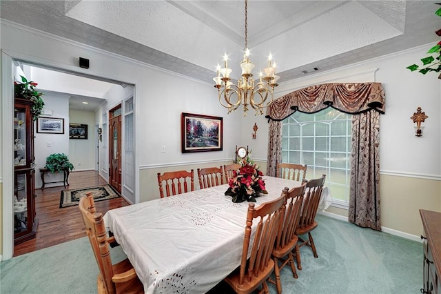 dining area with a raised ceiling, dark colored carpet, a textured ceiling, and a chandelier