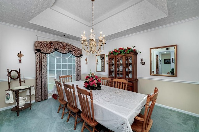 dining space with a raised ceiling, a textured ceiling, and a chandelier