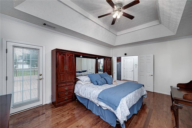 bedroom with a raised ceiling, access to outside, ceiling fan, and dark wood-type flooring