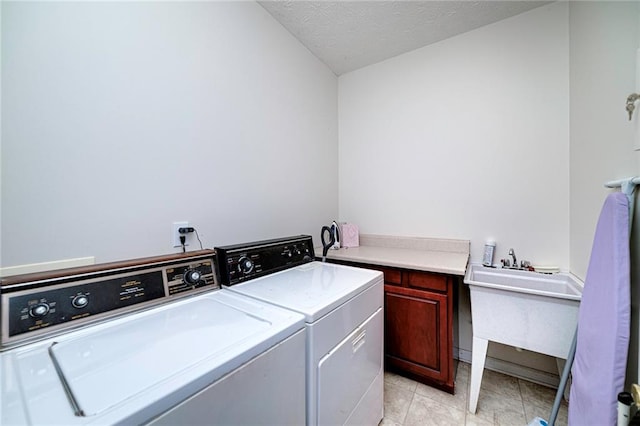 laundry area featuring sink, cabinets, washer and dryer, and light tile flooring