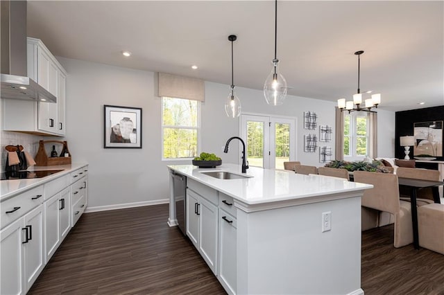 608 Belshire Dr, Acworth, GA 30102 - kitchen featuring wall chimney range hood, black electric cooktop, dark wood-style flooring, light countertops, and a chandelier