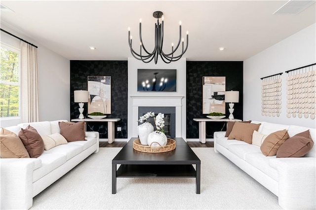 608 Belshire Dr, Acworth, GA 30102 - living room with an accent wall, a chandelier, a glass covered fireplace, wood finished floors, and recessed lighting