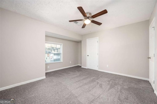 unfurnished bedroom featuring carpet, baseboards, a textured ceiling, and a ceiling fan