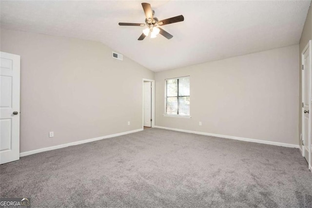 empty room with ceiling fan, carpet flooring, baseboards, and vaulted ceiling