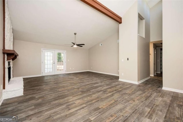 unfurnished living room with ceiling fan, wood finished floors, a fireplace, baseboards, and beamed ceiling