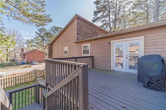 wooden terrace with french doors, fence, and a grill