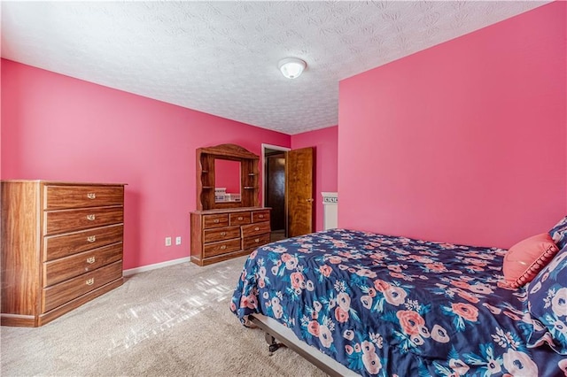 carpeted bedroom with a textured ceiling and baseboards