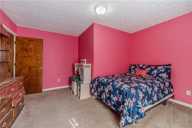 carpeted bedroom with a textured ceiling and baseboards