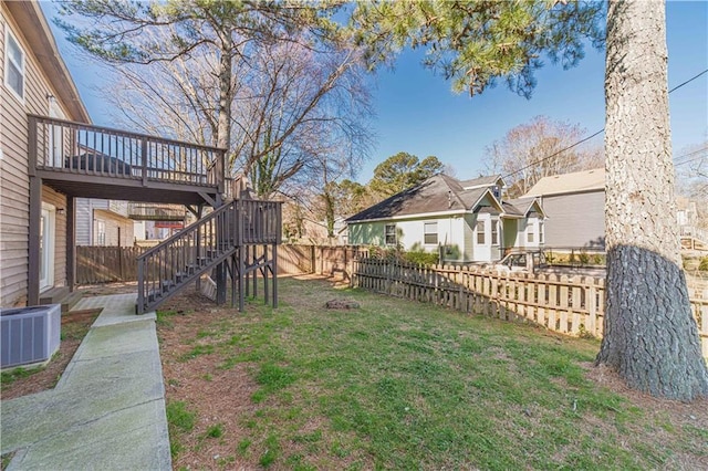 view of yard with a fenced backyard, a residential view, stairs, a deck, and cooling unit