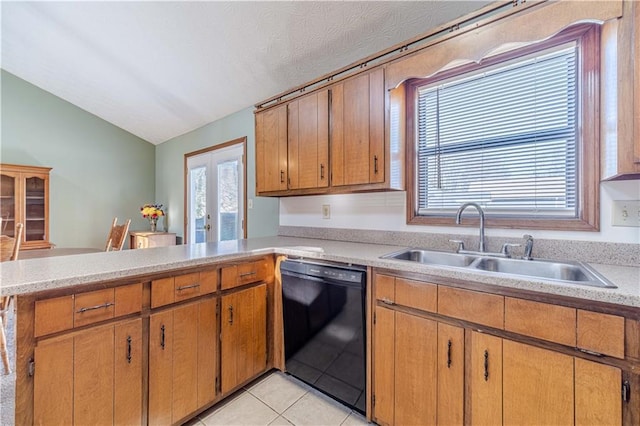 kitchen with french doors, light tile patterned floors, light countertops, a sink, and dishwasher