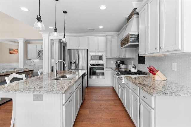 kitchen with decorative light fixtures, sink, appliances with stainless steel finishes, and a spacious island