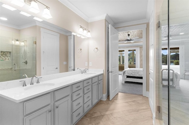 bathroom featuring ceiling fan, a shower with shower door, crown molding, and vanity