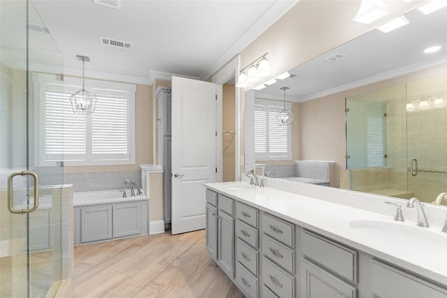 bathroom with vanity, a chandelier, hardwood / wood-style flooring, crown molding, and plus walk in shower