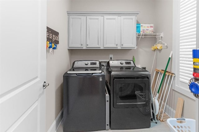 washroom with washing machine and dryer and cabinets