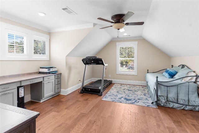 workout room with ceiling fan, lofted ceiling, and light hardwood / wood-style flooring