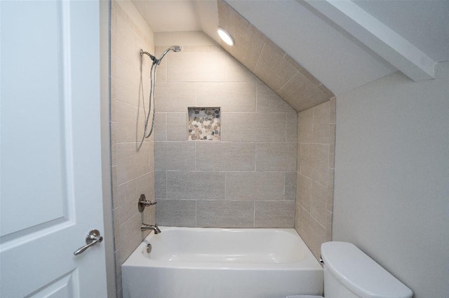 bathroom with toilet and tiled shower / bath