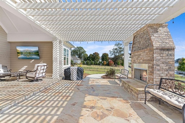 view of patio / terrace with a pergola and an outdoor brick fireplace