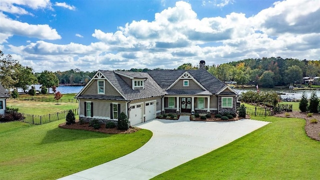 craftsman-style house featuring a garage, a front yard, and a water view