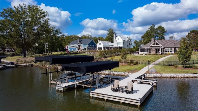 view of dock featuring a lawn and a water view