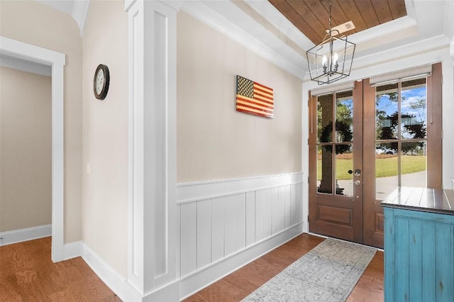 doorway to outside featuring wood-type flooring, an inviting chandelier, a healthy amount of sunlight, and french doors