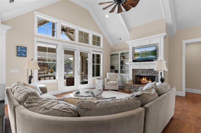 living room featuring ceiling fan, dark wood-type flooring, a stone fireplace, high vaulted ceiling, and french doors