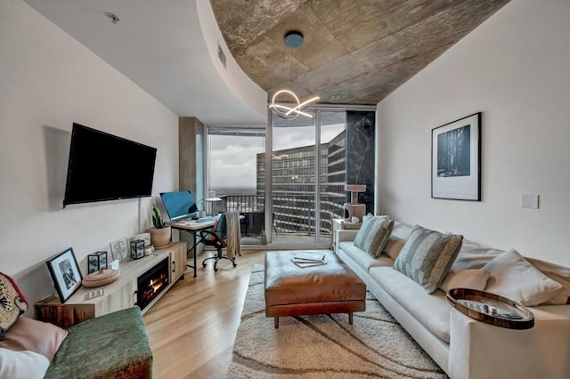 living room featuring floor to ceiling windows and light hardwood / wood-style flooring