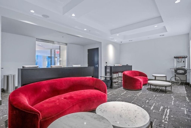 interior space with dark carpet and a tray ceiling