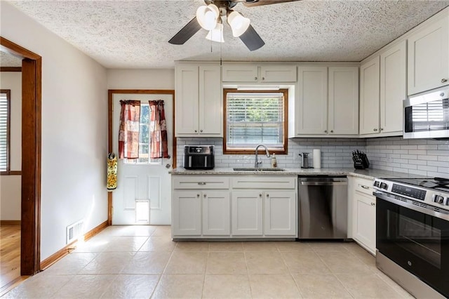 319 Hill Crest Cir, Woodstock, GA 30188 - kitchen featuring appliances with stainless steel finishes, backsplash, ceiling fan, a sink, and a textured ceiling