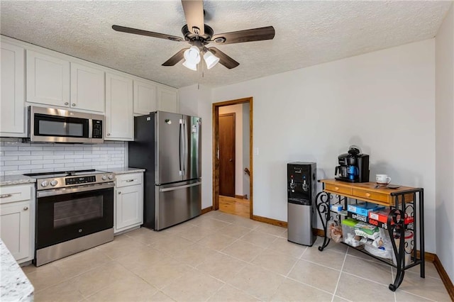 319 Hill Crest Cir, Woodstock, GA 30188 - kitchen with appliances with stainless steel finishes, a textured ceiling, ceiling fan, baseboards, and decorative backsplash