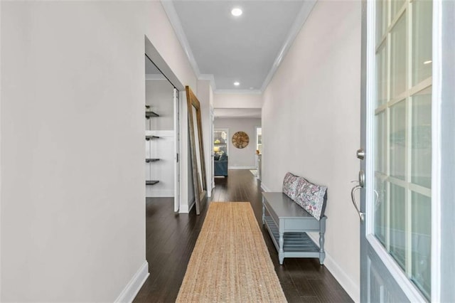 corridor featuring dark wood finished floors, recessed lighting, baseboards, and ornamental molding