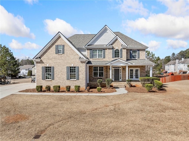 view of front of property featuring a front yard, fence, and brick siding