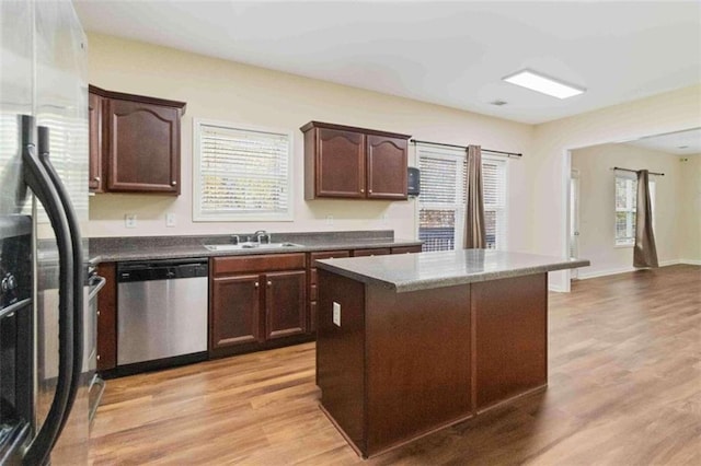 kitchen with light hardwood / wood-style flooring, sink, a kitchen island, dark brown cabinets, and appliances with stainless steel finishes