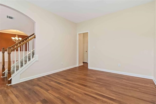 empty room featuring hardwood / wood-style flooring and a chandelier