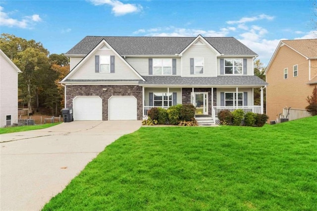 view of front of property featuring a front lawn, a garage, and covered porch