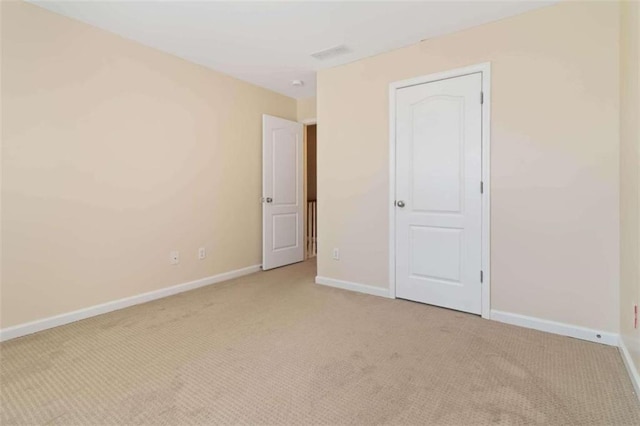 unfurnished room featuring light colored carpet