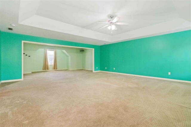 empty room with carpet and a tray ceiling