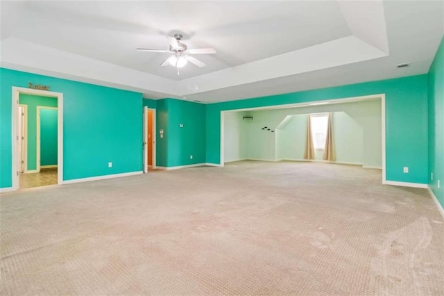 interior space with ceiling fan and a raised ceiling