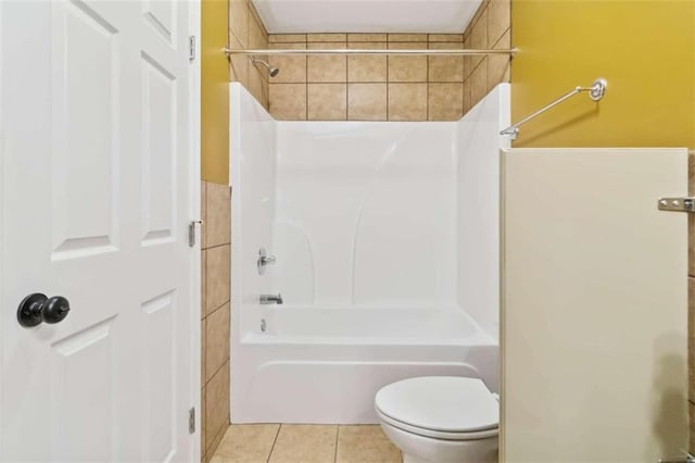 bathroom featuring toilet, tile patterned floors, and  shower combination