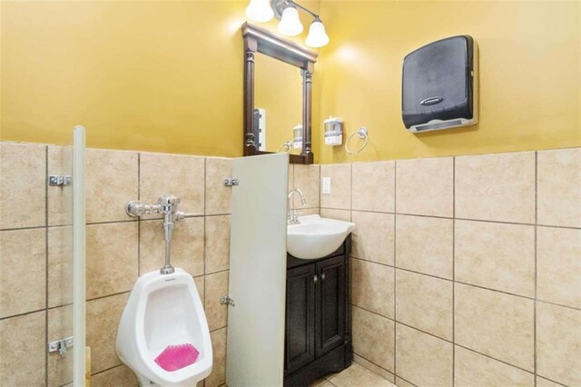 bathroom with vanity and tile walls