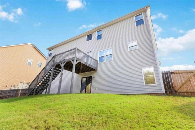 rear view of house featuring a yard and a wooden deck