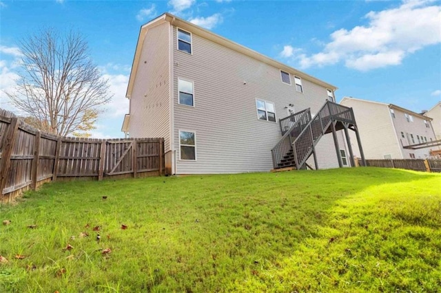 back of property featuring a deck and a yard