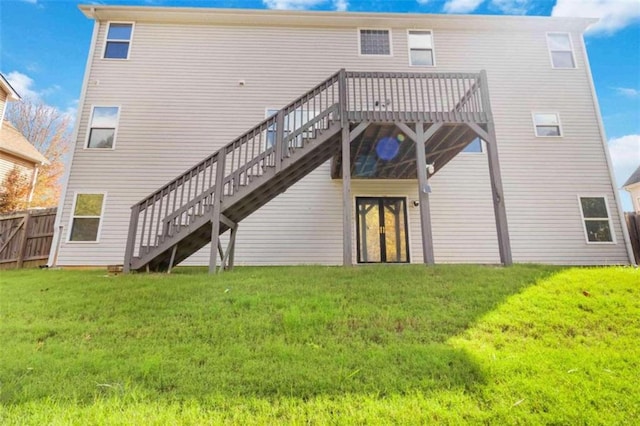 rear view of house featuring a lawn and a deck