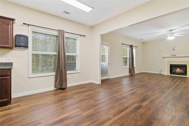 unfurnished living room with dark hardwood / wood-style floors and ceiling fan