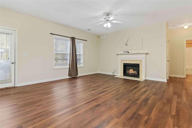 unfurnished living room with dark hardwood / wood-style flooring and ceiling fan